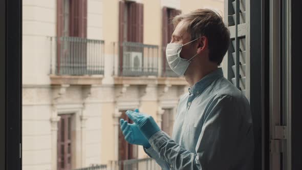 Young Man in a Mask and a Blue and White Shirt Applauding Doctors on the Balcony at 8 in the