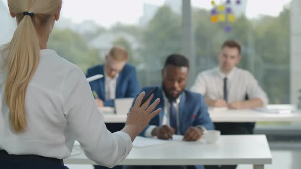 Back View of Female Business Coach Training Diverse Employees