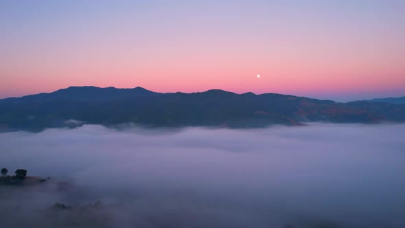 4K aerial view over a misty mountainous area. The great golden sun in the morning