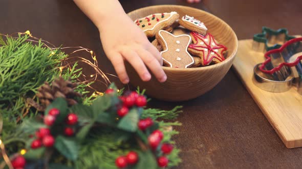 Unrecognizable Child Hand Takes Fresh Baked Decorated Christmas Cookie Pastry