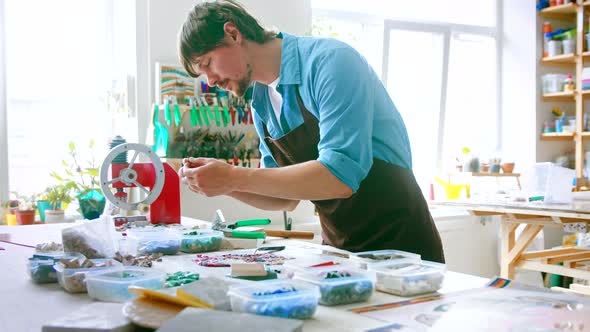 Young master in an apron at work in his workshop