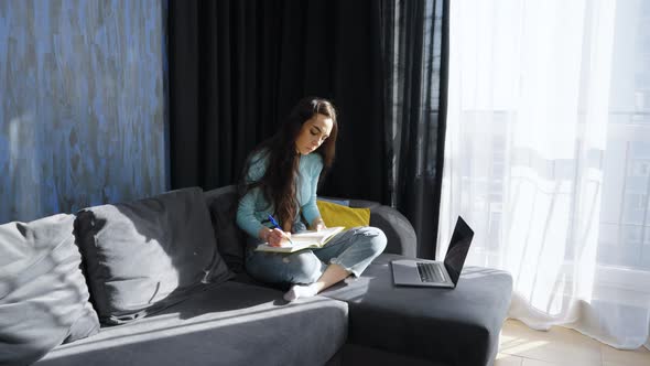 Woman Listening to Webinar and Making Notes