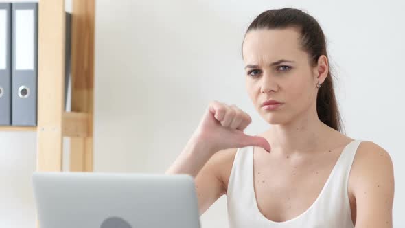 Thumbs Down Gesture By Woman at Work in Office