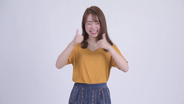 Happy Young Beautiful Asian Woman Looking Excited While Giving Thumbs Up