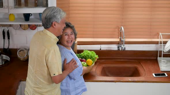 Asian senior couple cooking fruit healthy food in kitchen at home.