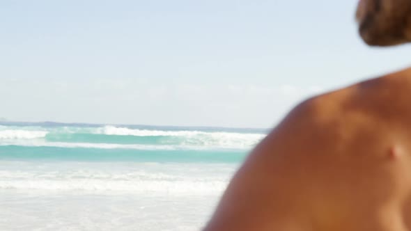 Male surfer standing in the beach 