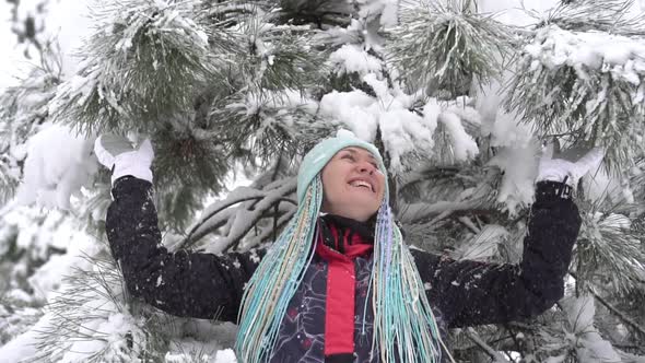 Snow Falls From a Tree on a Happy Woman