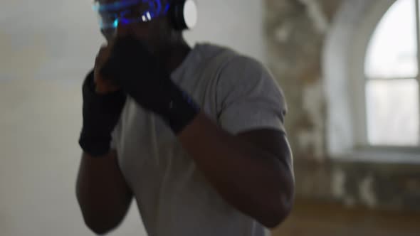 Young Male Boxer Practicing Shadow Boxing in Light Sport Studio Close Up