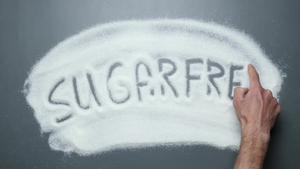 Sugarfree word written on sugar surface. Stop diabetes. Prevent obesity and cardiovascular diseases.