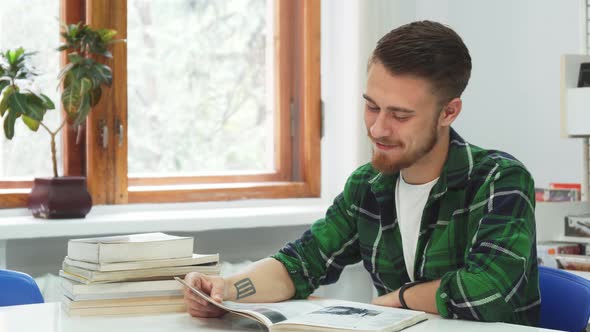 A Cute Guy Laughs at What He Read in the Book