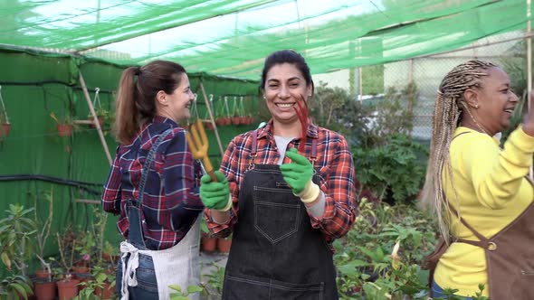 Multiracial women having fun dancing inside garden center