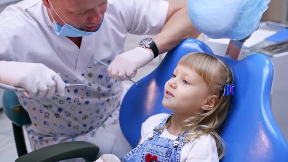 Little child in stomatology chair - close up. Girl with dentist. Health teeth concept. 