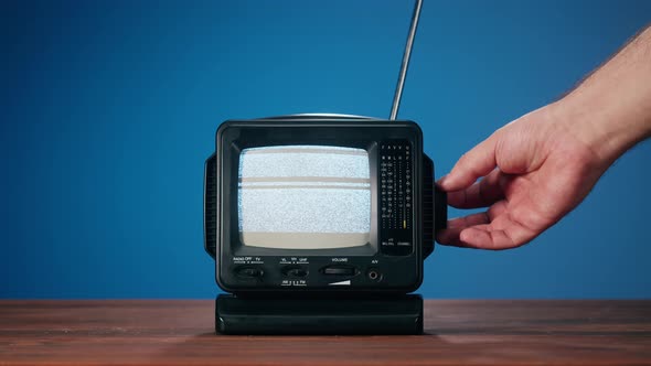 Small Old Television with Grey Interference Screen on Blue Background