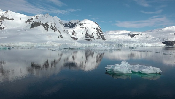 Icebergs are reflected in the water. Antarctic Nature. Majestic winter landscape.