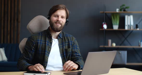 Handsome Operator in Call-Center, Technical Support is working Indoor, smiling at the Camera.