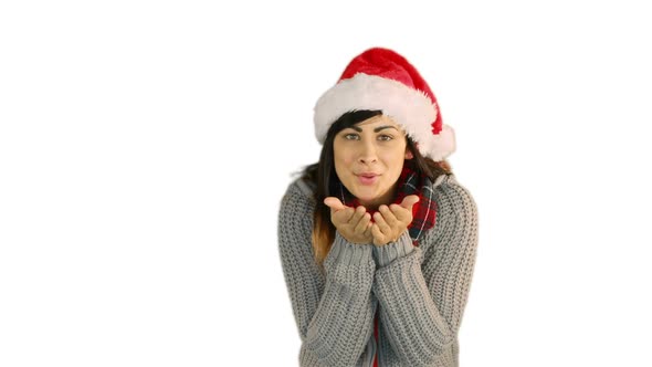 Woman in santa hat and warm clothing blowing over hands