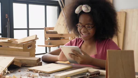 Social media addiction. African-Thai teen using tablet while studying carpentry