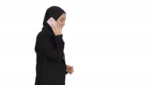 Attractive Modern Muslim Woman Walking and Talking on Cell Phone on White Background