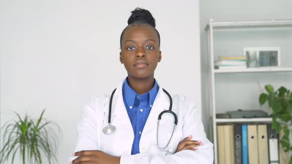 Young Adult Smiling Black Female Doctor Looking at Camera Standing Arms Crossed