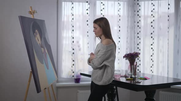 Side View Portrait of Slim Young Woman Looking at Picture on Easel Shaking Head Sighing Leaving