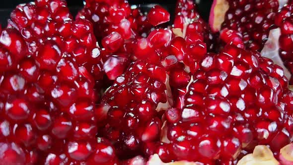 Grains of Ripe Pomegranate Are Falling on the Surface of Broken Pomegranate
