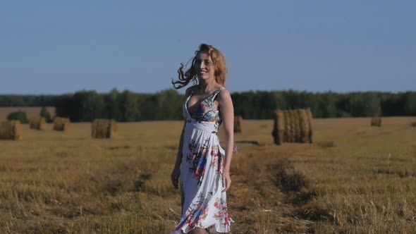 Portrait of Attractive Redhead Woman Dancing Against Background of Fields