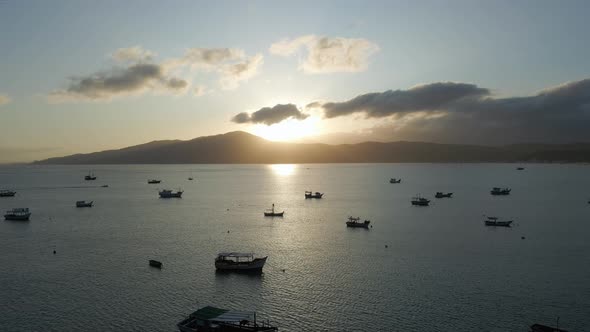 Sunset Bay with Small Boats Anchored near the Beach, Aerial Pullback.