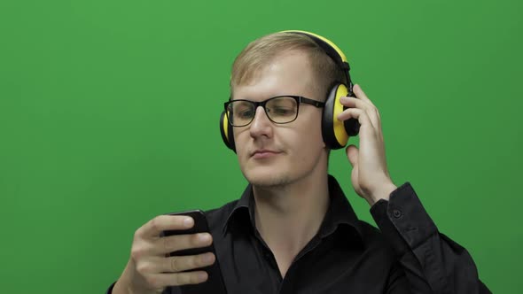 Guy Listens To Music in Wireless Yellow Headphones and Dances, Chroma Key