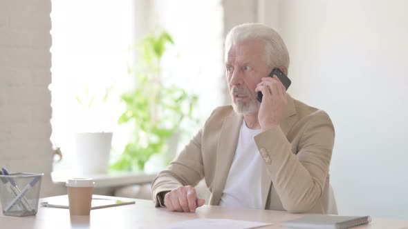 Old Man Talking on Phone in Office