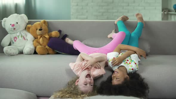 Little Multiracial Children Lying on Sofa and Having Fun at Home, Childhood