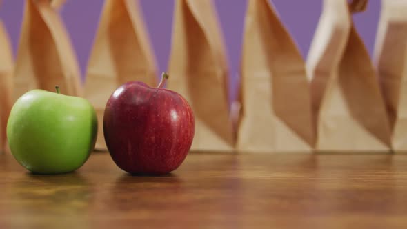 Animation of paper lunch bags an fruits on wooden table