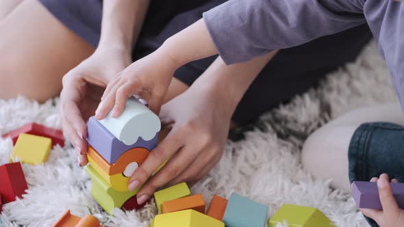 Beautiful Mother and Toddler Daughter Are Playing Construction Toys Together in a Room