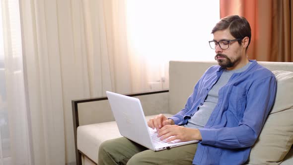 Relaxed Serious Millennial Guy Student or Freelancer Using Laptop Device