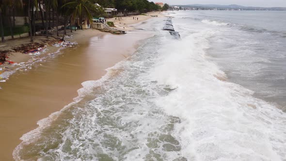 Line of concrete geo tube protecting Vietnam sandy beach from erosion, aerial view. Powerful waves r