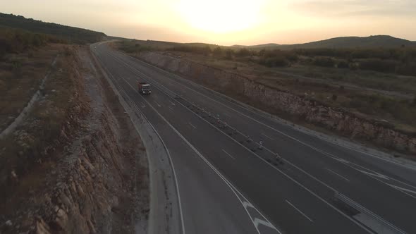 Aerial View of Work Truck Driving on Empty Highway at Sunset