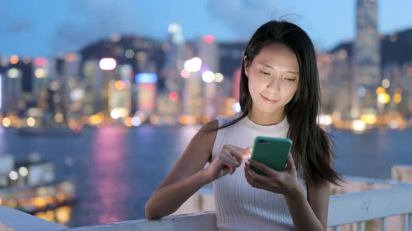 Woman using cellphone at night