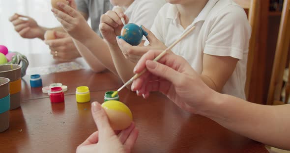 Mother and Her Boys Color a Yellow Easter Egg