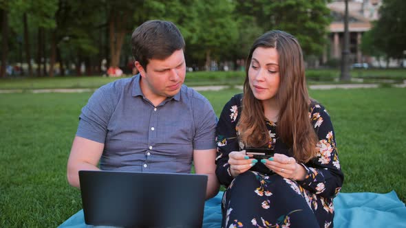 Young Couple Shopping Online Using Laptop and Credit Card