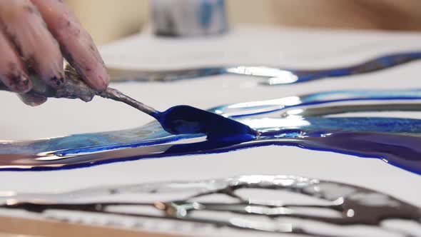 Applying Dark Blue Epoxy Resin on the Painting Using a Spatula