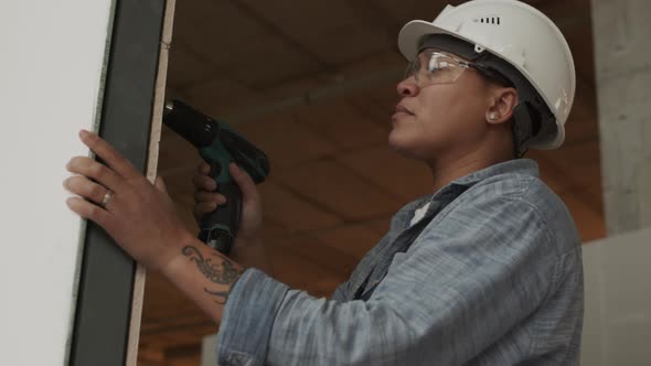 Mixed-Race Worker Using Drill