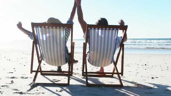 Senior couple relaxing on sunlounger at beach