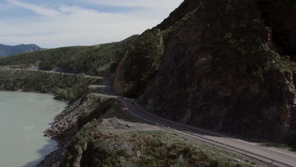 Traffic cars on Chuya highway road between mountains and Katun river in Altai