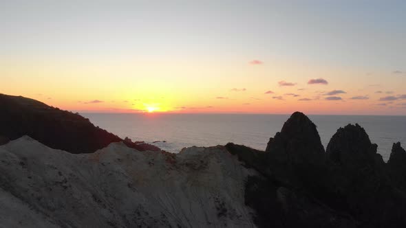 drone flight over a cliff into the sunset