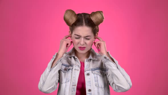 Girl Screams, She Does Not Want To Hear Anything. Pink Background. Slow Motion