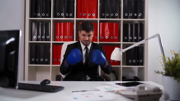 Businessman Wearing Boxing Gloves in Office