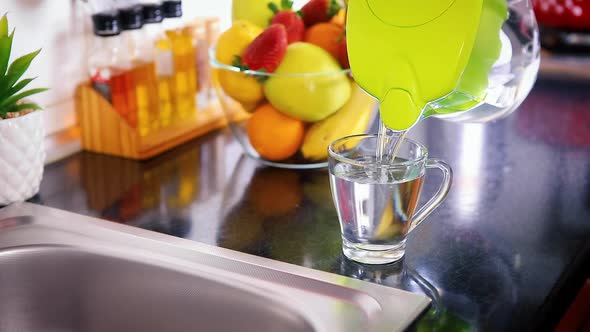 Pouring Filtered Water into Glass from Jug