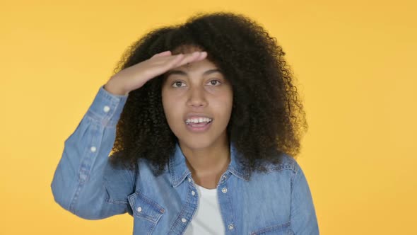 African Woman Looking Around Searching Yellow Background