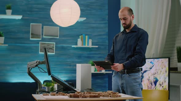 Man Architect Holding Tablet with Building Model