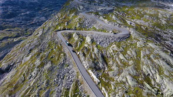 Vehicles driving up on a dangerous and curvy mountain pass road, Aerial view