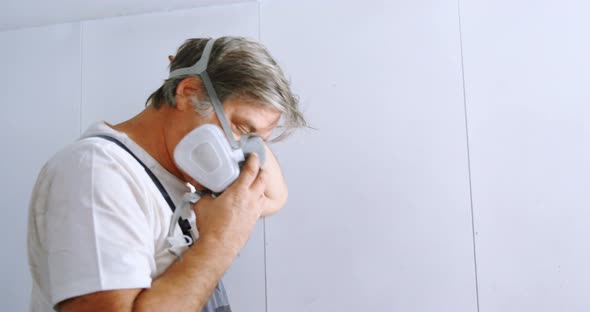 Male mechanic wearing gas mask 